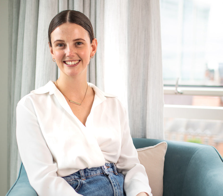 Image of Co-Founder, Darcy Laceby, sat on blue chair